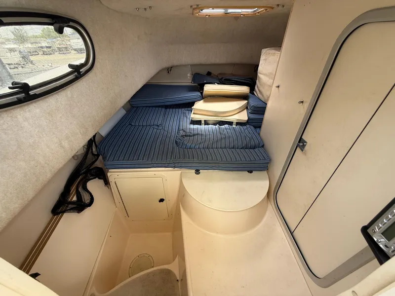 Slide: The Image of 1997 Grady-White F-26 Tigercat cabin interior with blue cushions and storage compartments. - 15