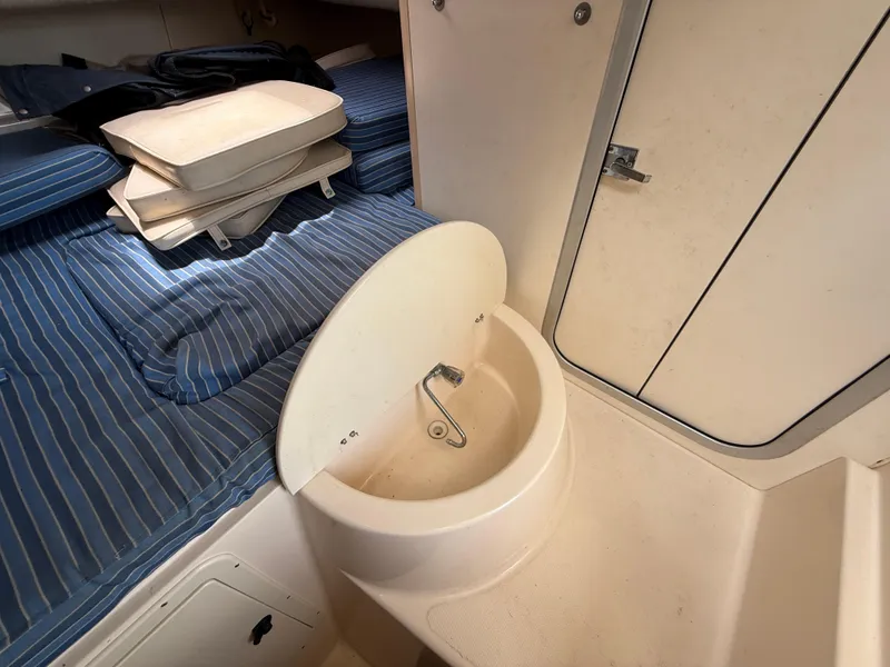 Slide: The Image of 1997 Grady-White F-26 Tigercat cabin interior with sink and striped bedding. - 17