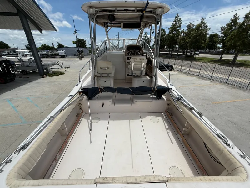 Slide: The Image of 1997 Grady-White F-26 Tigercat boat, spacious deck, parked outdoors under clear sky. - 8