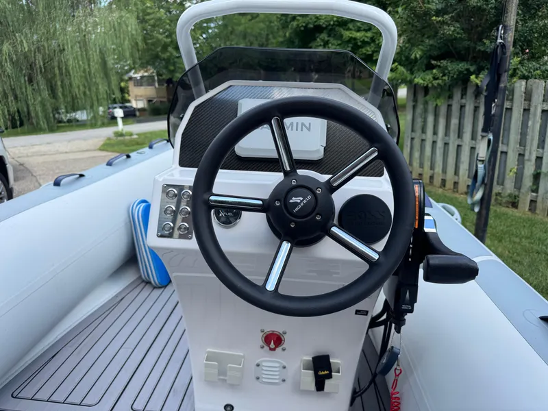 Slide: The Image of 2023 Highfield Classic 420 boat steering console with controls and Garmin display. - 5