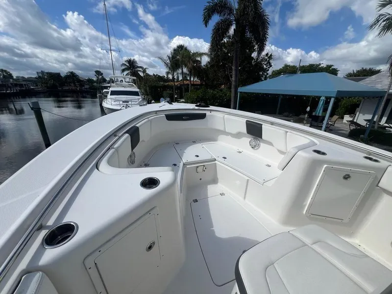 Slide: The Image of 2018 Robalo R302 Center Console boat interior with seating, cup holders, and storage compartments. - 13