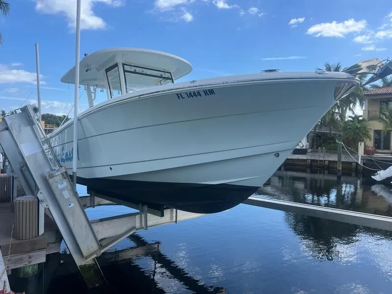 Slide: The Image of 2018 Robalo R302 Center Console boat on lift by waterfront. - 2
