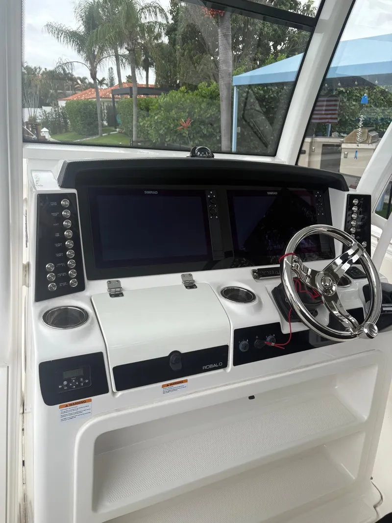 Slide: The Image of 2018 Robalo R302 Center Console dashboard with dual screens and steering wheel. - 21