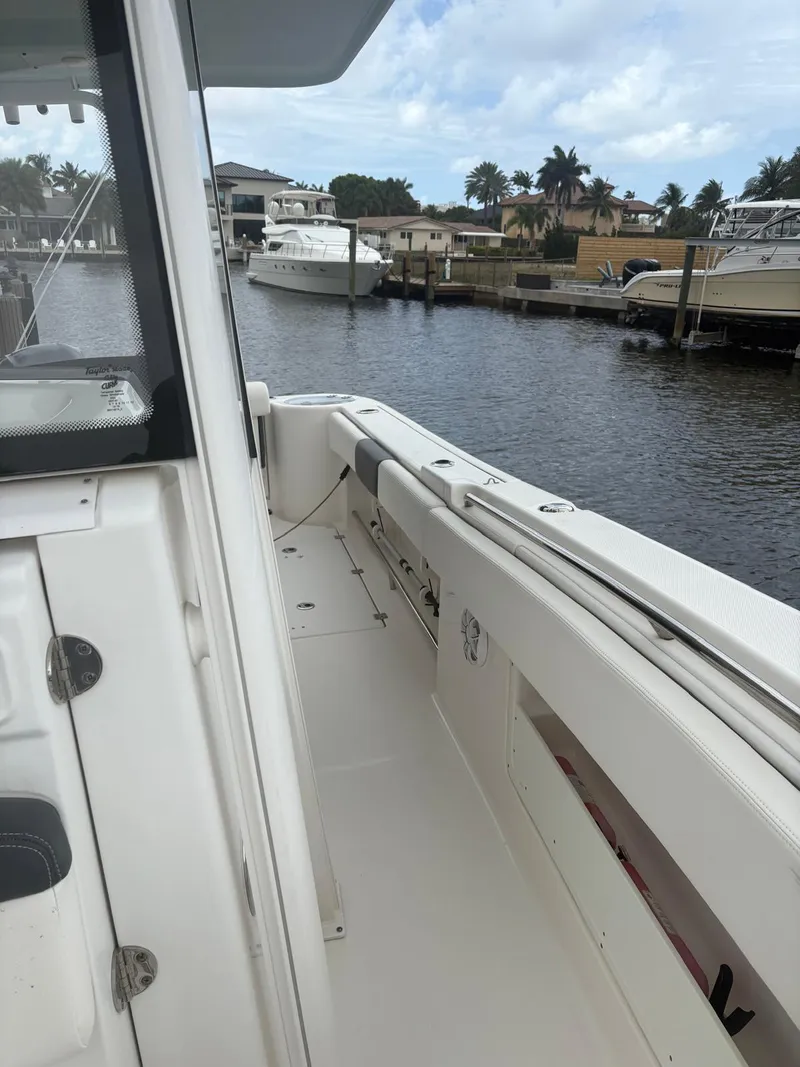 Slide: The Image of 2018 Robalo R302 Center Console boat docked in a marina, featuring spacious deck and sleek design. - 28