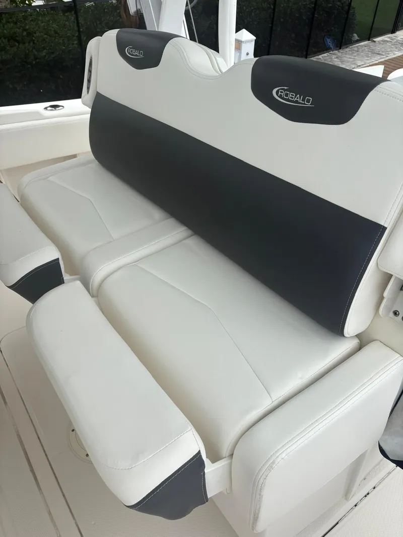 Slide: The Image of 2018 Robalo R302 Center Console boat seating, featuring white and black cushioned design. - 34