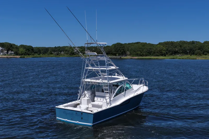 Slide: The Image of 2018 Albemarle 36 Express boat on a serene lake with lush green shoreline. - 11
