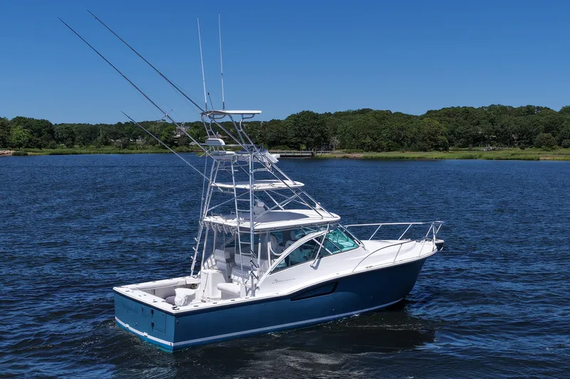 Slide: The Image of 2018 Albemarle 36 Express boat on a serene lake with lush green shoreline. - 12