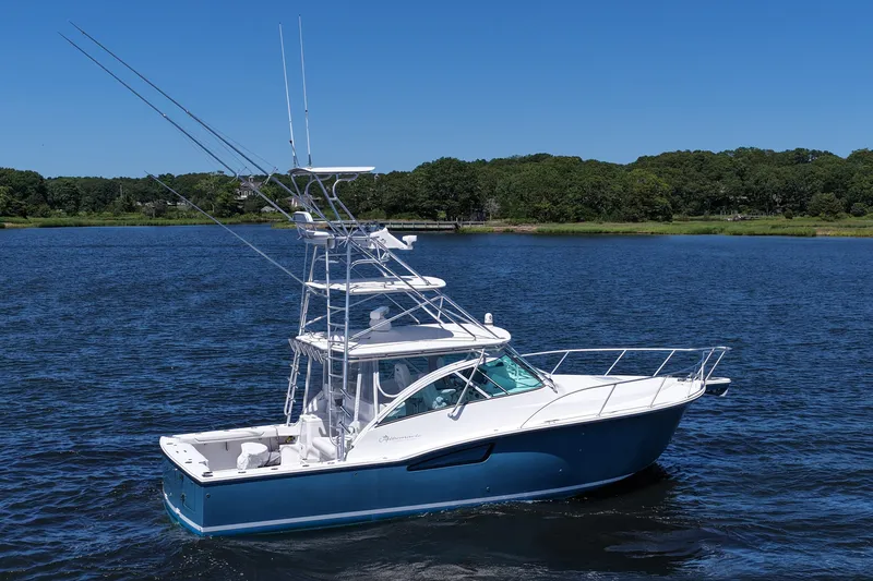 Slide: The Image of 2018 Albemarle 36 Express boat cruising on a serene lake under a clear blue sky. - 13