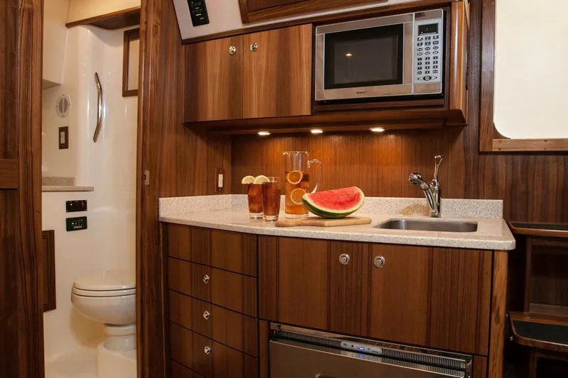 Slide: The Image of Manufacturer Provided Image: 2018 Albemarle 36 Express yacht interior kitchen with microwave, sink, and refreshments. - 29