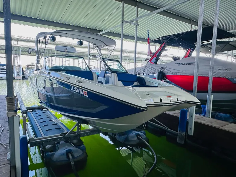 Slide: The Image of 2018 MasterCraft X23 boat docked in a covered marina. - 13