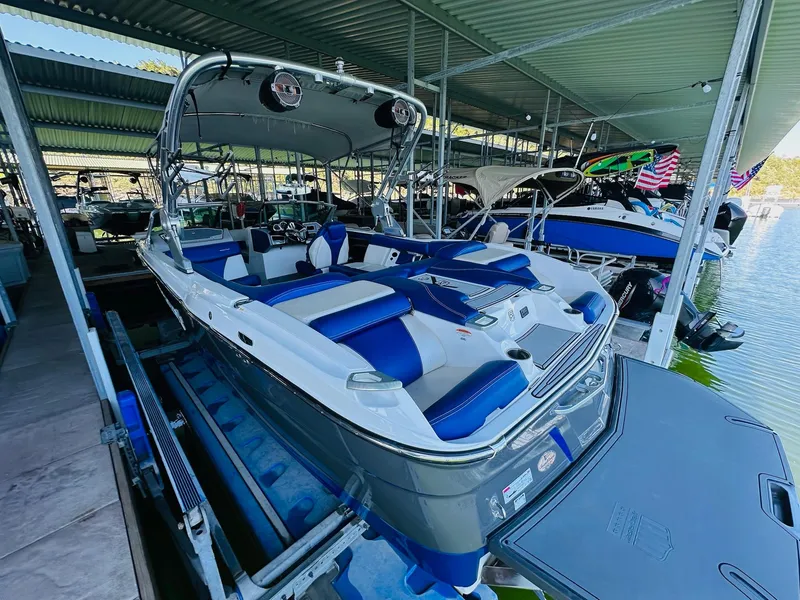 Slide: The Image of 2018 MasterCraft X23 boat with blue and white interior, docked in a covered marina. - 15