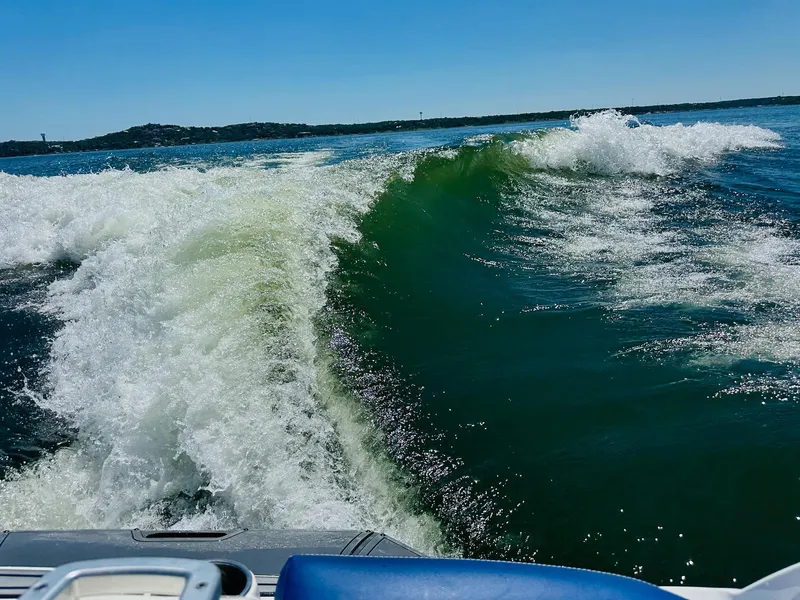 Slide: The Image of 2018 MasterCraft X23 creating a large wake on a sunny lake. - 26