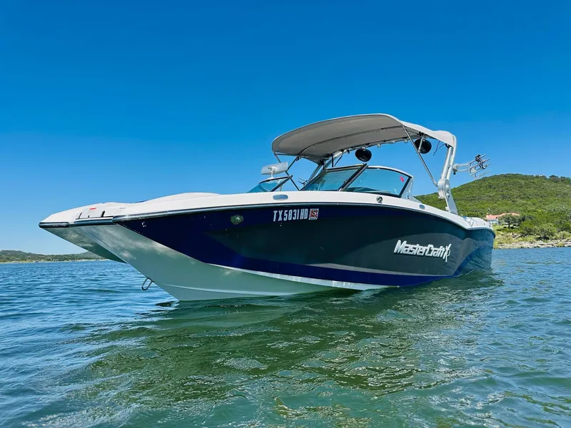 Slide: The Image of 2018 MasterCraft X23 boat on clear water under blue sky. - 6