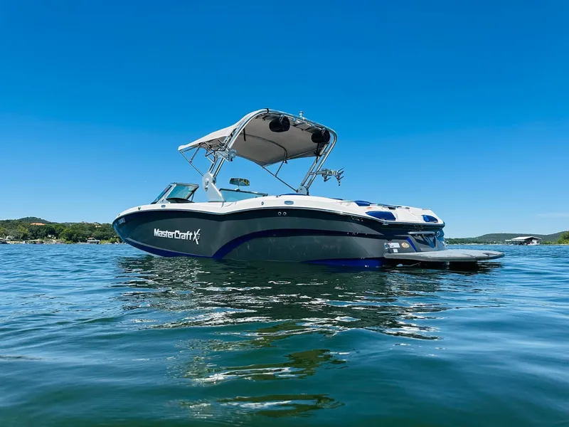 Slide: The Image of 2018 MasterCraft X23 boat on a sunny lake, showcasing sleek design and vibrant blue water. - 7