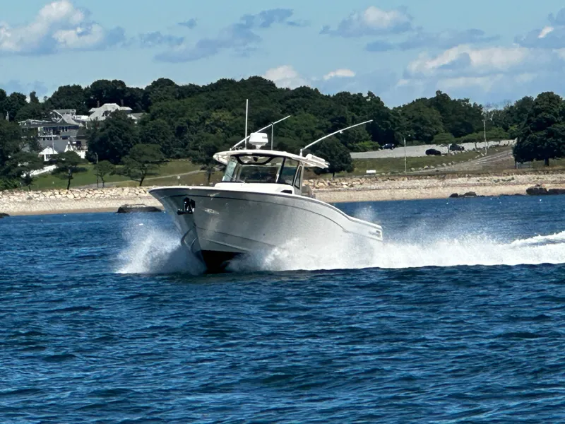 Slide: The Image of 2017 Grady-White Canyon 376 boat cruising on blue water near a scenic shoreline. - 15