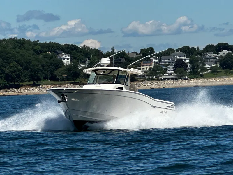 Slide: The Image of 2017 Grady-White Canyon 376 boat cruising on water near a scenic shoreline. - 16