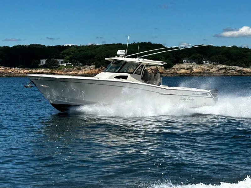Slide: The Image of 2017 Grady-White Canyon 376 boat cruising on water near rocky shoreline. - 17