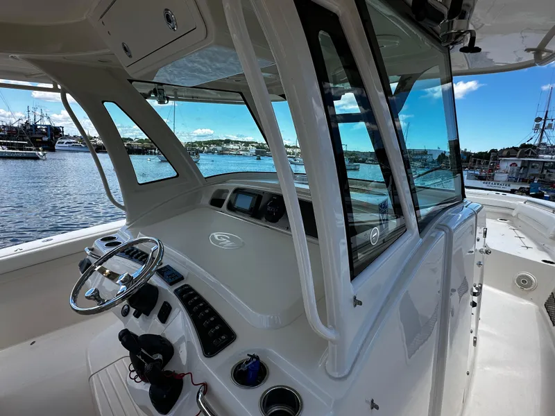 Slide: The Image of 2017 Grady-White Canyon 376 boat interior with steering wheel and control panel, docked at marina. - 18
