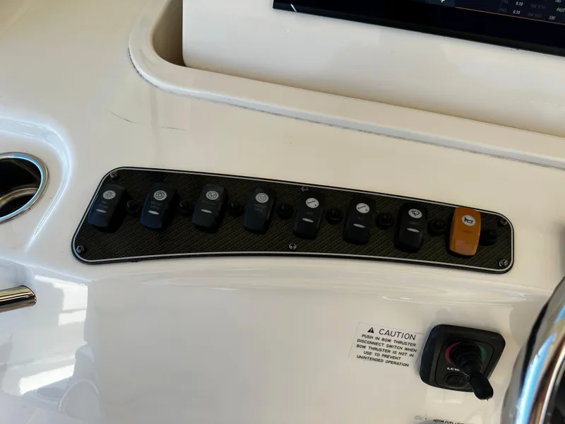 Slide: The Image of Control panel of a 2017 Grady-White Canyon 376 boat with various switches and caution label. - 22