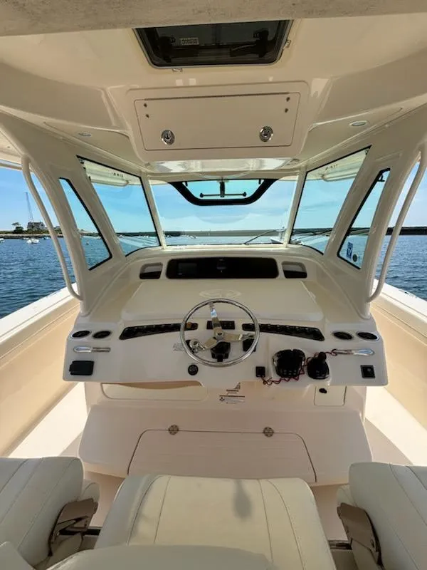Slide: The Image of 2017 Grady-White Canyon 376 boat helm with steering wheel and controls, overlooking water. - 25