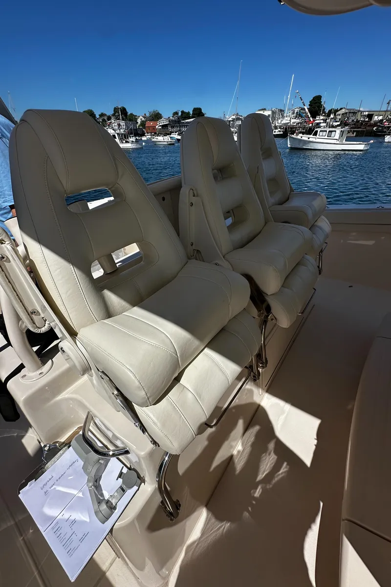 Slide: The Image of 2017 Grady-White Canyon 376 boat interior with luxurious seating, docked at a marina. - 34