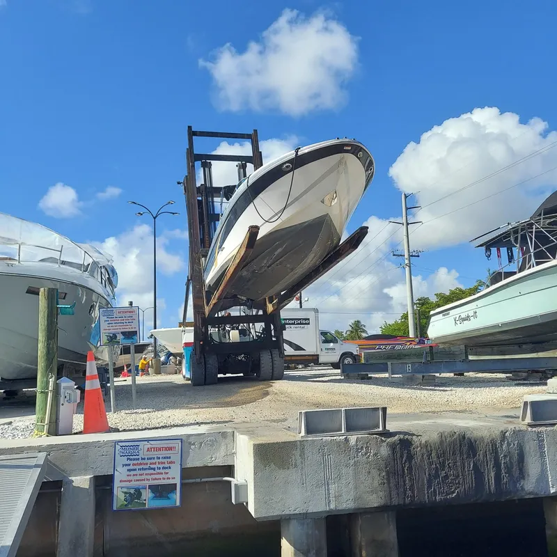 Slide: The Image of 2007 Four Winns 240 Horizon boat lifted at marina under clear blue sky. - 2