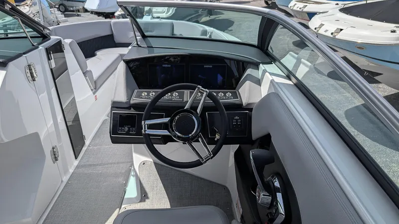 Slide: The Image of 2026 Four Winns H6 OB boat cockpit with modern steering and dashboard controls. - 13