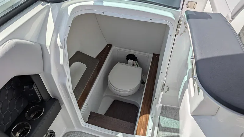 Slide: The Image of 2026 Four Winns H6 OB boat interior with compact marine toilet. - 16