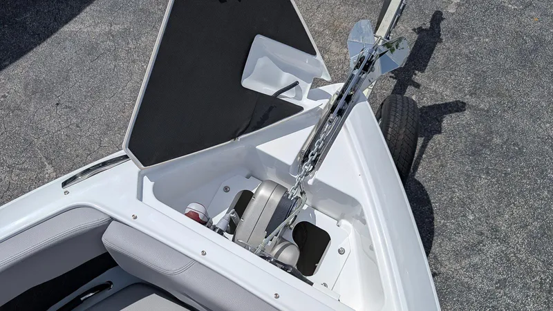 Slide: The Image of 2026 Four Winns H6 OB boat anchor compartment with open hatch, showcasing storage and anchor chain. - 19