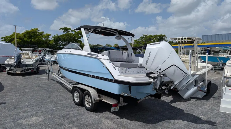 Slide: The Image of 2026 Four Winns H6 OB boat with Mercury outboard engine on trailer. - 2
