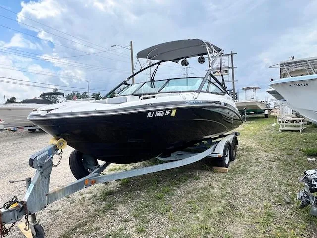 Slide: The Image of 2013 Yamaha Boats 212X on trailer, parked outdoors under cloudy sky. - 1