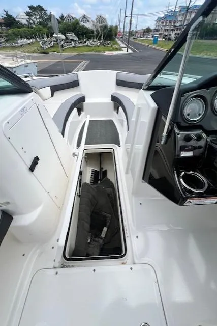 Slide: The Image of 2013 Yamaha Boats 212X interior with open storage compartment and dashboard view. - 11