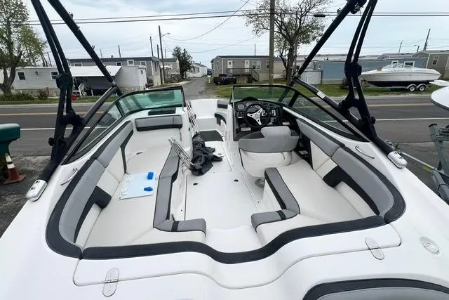 Slide: The Image of 2013 Yamaha Boats 212X interior with seating and steering wheel, parked near mobile homes. - 14