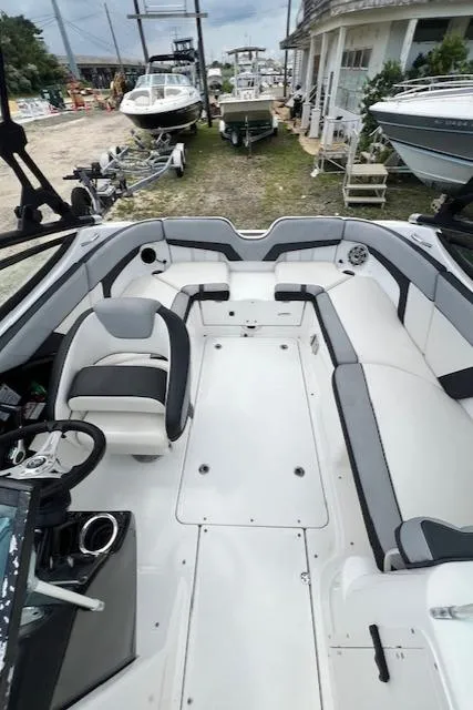 Slide: The Image of 2013 Yamaha Boats 212X interior with seating and steering wheel, docked among other boats. - 3