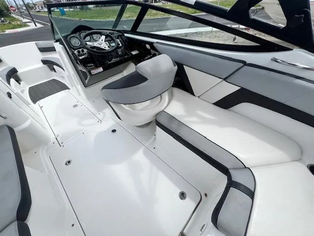 Slide: The Image of 2013 Yamaha Boats 212X interior with sleek white and gray seating and modern dashboard. - 8
