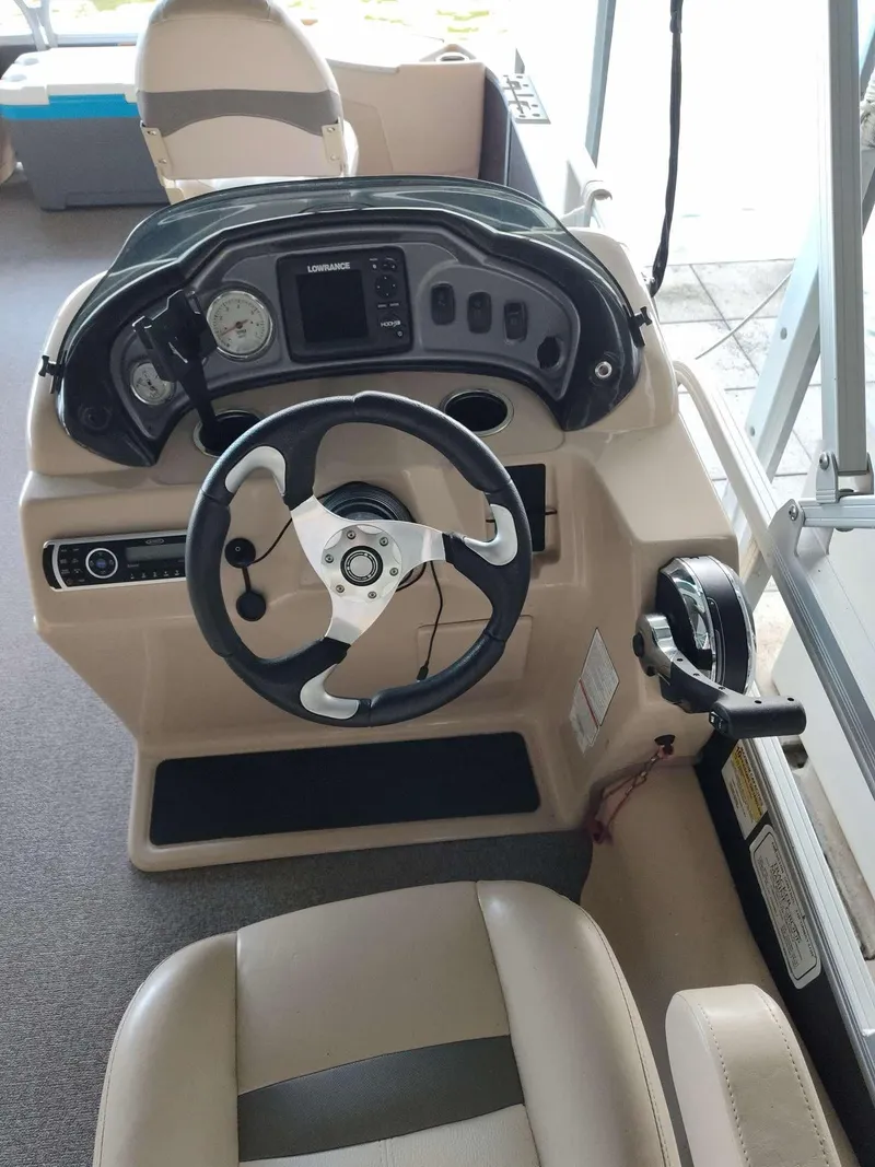 Slide: The Image of 2016 Sun Tracker Fishin' Barge 22 DLX helm with steering wheel and control panel. - 6