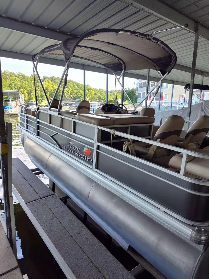 Slide: The Image of 2016 Sun Tracker Fishin' Barge 22 DLX pontoon boat docked under a covered marina. - 7
