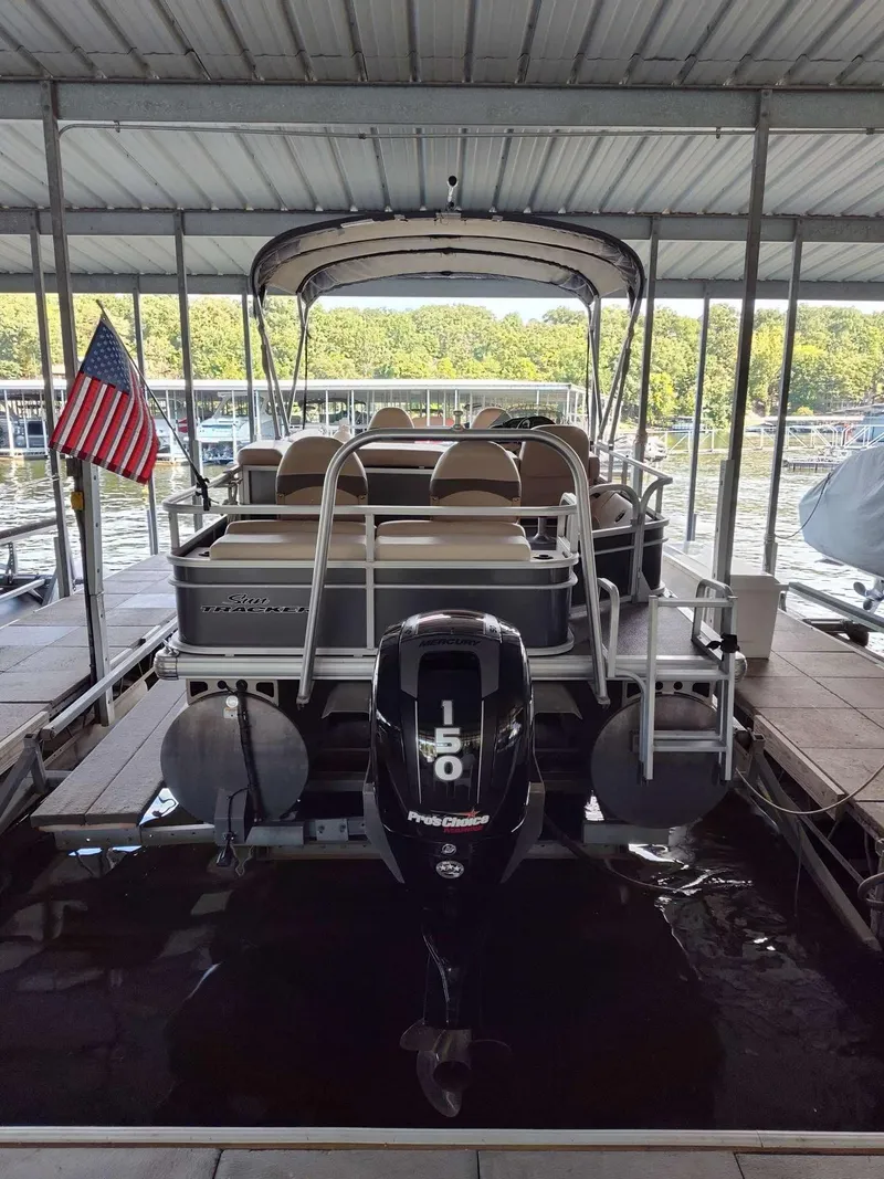 Slide: The Image of 2016 Sun Tracker Fishin' Barge 22 DLX pontoon boat docked with American flag. - 8