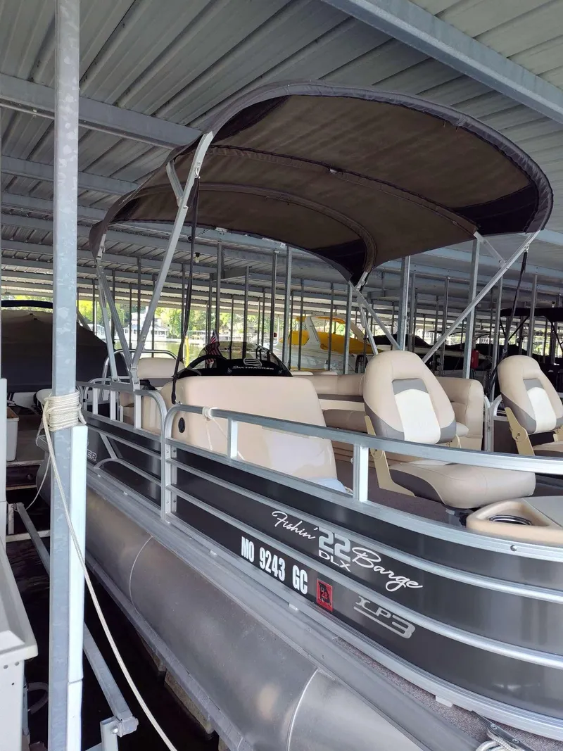 Slide: The Image of 2016 Sun Tracker Fishin' Barge 22 DLX pontoon boat docked under a covered marina. - 9
