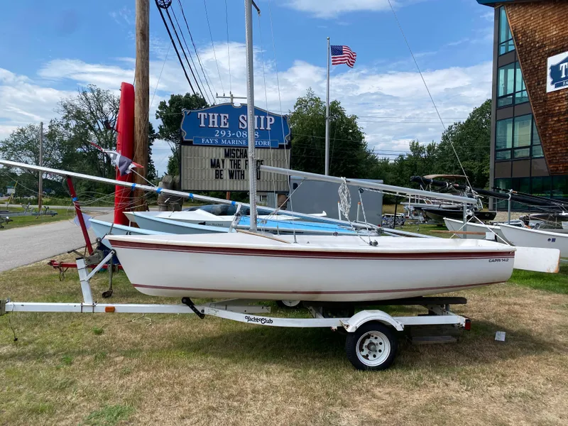 The Image of 1986 Catalina Capri 14.2 sailboat on trailer at marina with American flag. - 1