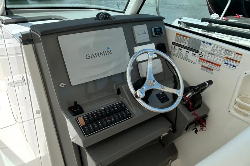 Slide: The Image of 2015 Pursuit DC 325 Dual Console helm with Garmin navigation system and steering wheel. - 10
