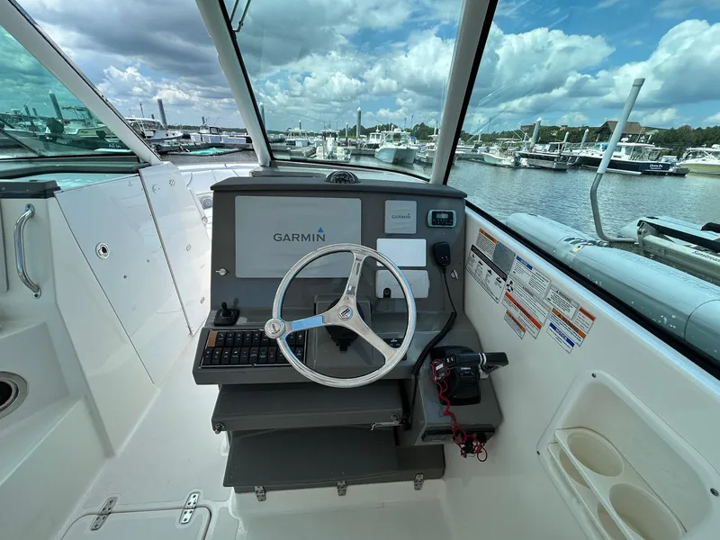 Slide: The Image of 2015 Pursuit DC 325 Dual Console boat helm with Garmin navigation, docked at marina. - 11