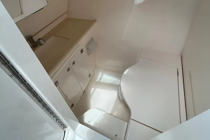 Slide: The Image of 2015 Pursuit DC 325 Dual Console boat interior with sink and storage cabinets. - 14