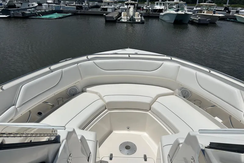 Slide: The Image of 2015 Pursuit DC 325 Dual Console boat interior with white seating at marina. - 15