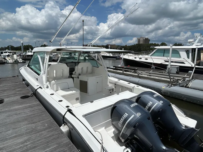 Slide: The Image of 2015 Pursuit DC 325 Dual Console boat docked with twin Yamaha engines. - 2