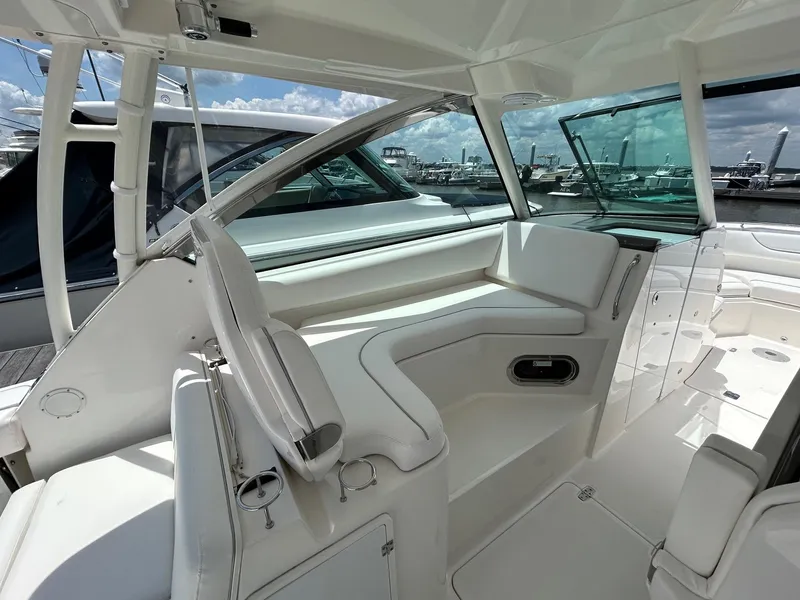 Slide: The Image of 2015 Pursuit DC 325 Dual Console boat interior with white seating and open deck view. - 6