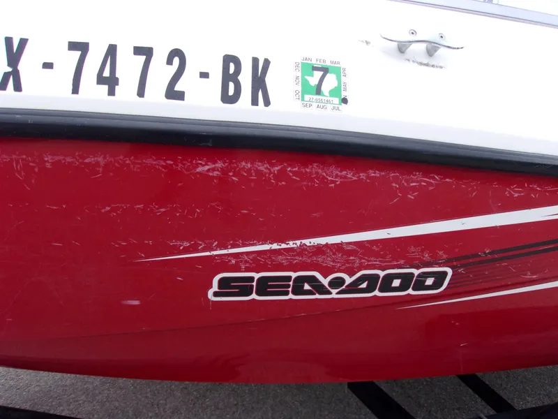 Slide: The Image of 2010 Sea-Doo 180 Challenger SE boat with red hull and visible registration number. - 3
