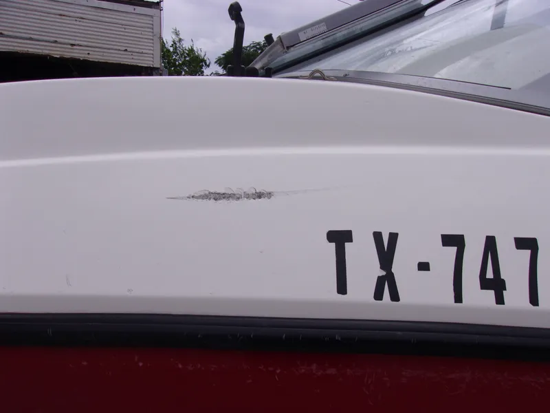 Slide: The Image of 2010 Sea-Doo 180 Challenger SE with visible hull scratch and registration number TX-747. - 4