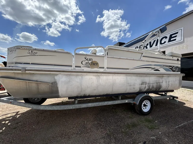Slide: The Image of 2006 SunCatcher LX 20 Fish & Cruise pontoon boat on trailer, parked outdoors. - 2