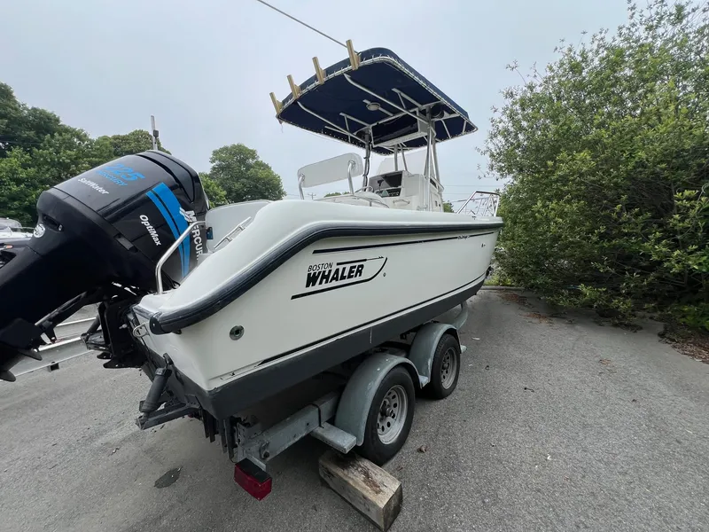 Slide: The Image of 2001 Boston Whaler 21 Outrage boat on trailer, featuring Mercury OptiMax engine. - 4